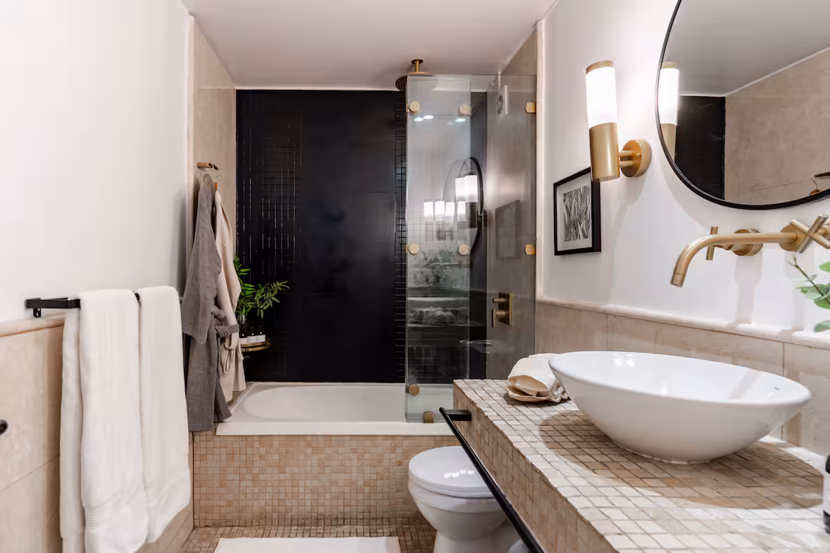 Baño con tina, ducha de vidrio y vanitorio