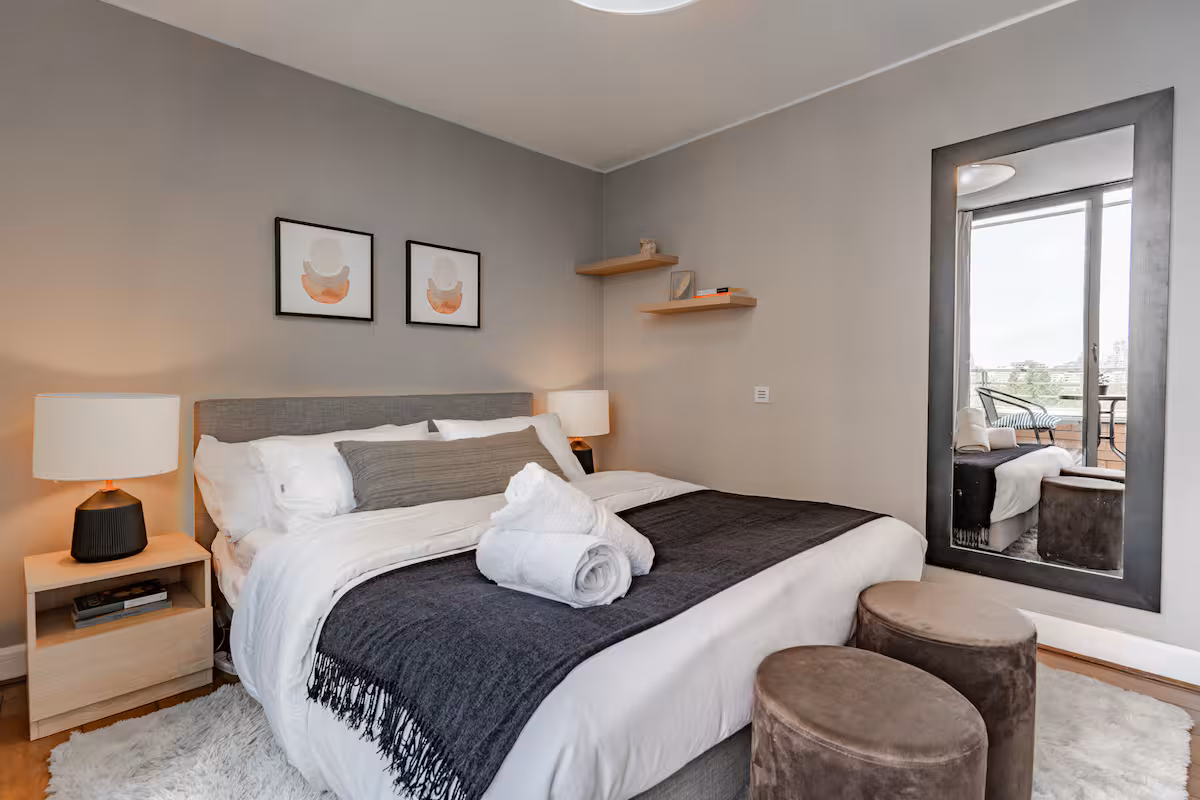 Dormitorio con cama queen y espejo de piso