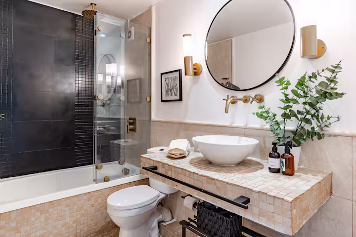 Baño en suite con ducha de vidrio y azulejo negro