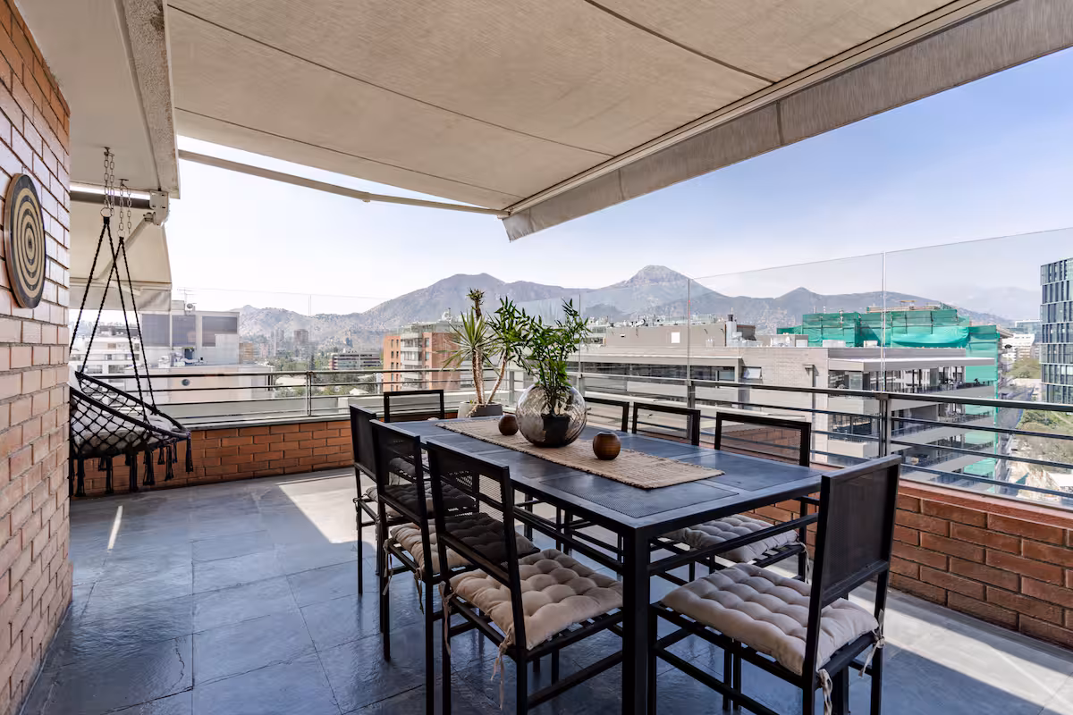 Terraza con comedor exterior y vista a la cordillera
